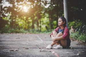 niña triste sentada en un parque foto