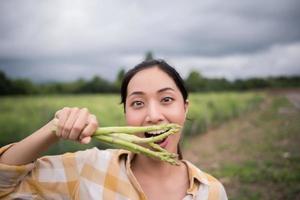 Close-up of pretty farmer collecting asparagus photo