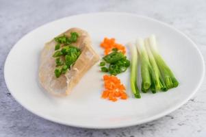 Steamed chicken breast with spring onions and chopped carrots photo