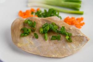 Steamed chicken breast with spring onions and chopped carrots photo