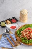 Thai papaya salad with sticky rice, spoon and fork photo