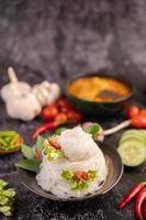 Chicken curry in a black cup with rice noodles photo