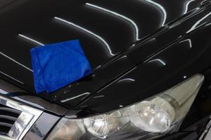 Microfiber cloth on the hood of a black car photo