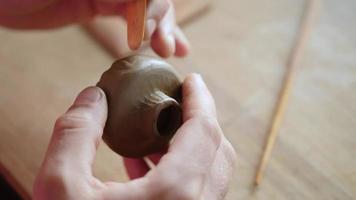 mani di un uomo che scolpisce una ciotola di terracotta video