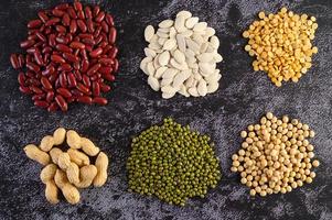 Legumes and beans assorted on a black cement surface photo