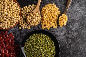 Legumes and beans assorted on a black cement surface photo