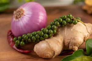 Red onion, pepper and ginger on a wooden table photo