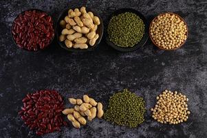 Legumes and beans assorted on a black cement surface photo