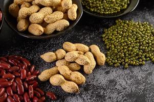 Legumes and beans assorted on a black cement surface photo