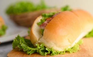 Close-up of a hotdog with bacon on wooden cutting board photo