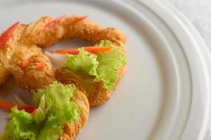 Freshly baked soft pretzel on a white dish photo