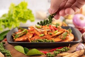 Chu-chi shrimp on a plate with fresh pepper seeds photo