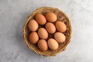 huevos marrones frescos en una cesta de mimbre foto