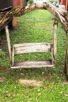 Wooden porch swing in garden photo