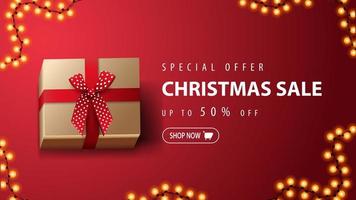 oferta especial, venta de navidad, hasta 50 de descuento, banner de descuento rojo con presente con lazo rojo sobre fondo rojo, vista superior vector