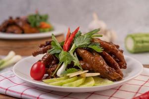 Sweet fried chicken feet with coriander, chili, cucumber and tomato photo