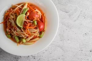 Thai papaya salad on a white plate photo