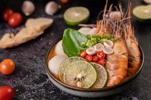 Tom yum soup with shrimp and crab with lime, chili, tomato and garlic photo