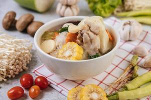 Chicken soup with corn, shiitake mushroom, enoki mushroom and carrot photo