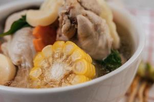 Chicken soup with corn, shiitake mushroom, enoki mushroom and carrot photo