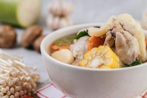 Chicken soup with corn, shiitake mushroom, enoki mushroom and carrot photo