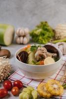 Chicken soup with corn, shiitake mushroom, enoki mushroom and carrot photo