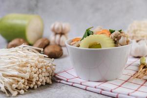 Chicken soup with corn, shiitake mushroom, enoki mushroom and carrot photo