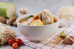 Chicken soup with corn, shiitake mushroom, enoki mushroom and carrot photo