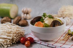 Chicken soup with corn, shiitake mushroom, enoki mushroom and carrot photo