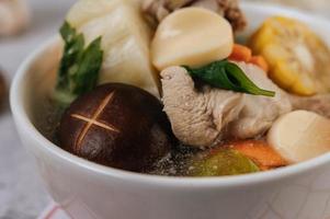 Chicken soup with corn, shiitake mushroom, enoki mushroom and carrot photo