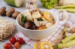 Chicken soup with corn, shiitake mushroom, enoki mushroom and carrot photo