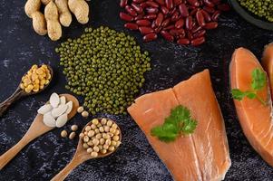 Legumes with salmon on a black cement background photo
