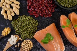 Legumes with salmon on a black cement background photo