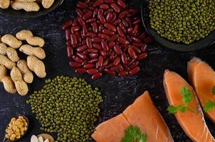 Legumes with salmon on a black cement background photo