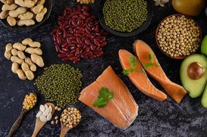 Legumes, fruit, and salmon on a black cement background photo