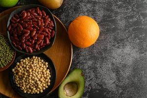 Legumes and fruit on black cement floor background photo