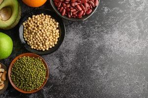 Legumes and fruit on black cement floor background photo