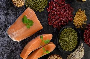 Legumes with salmon on a black cement background photo
