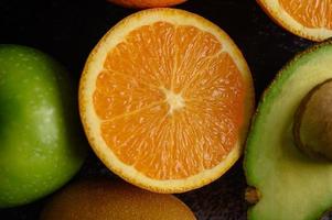 Rebanada de primer plano brillante de manzana naranja fresca, kiwi y aguacate