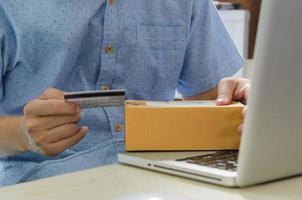 Man holding a credit card and a cardboard box photo