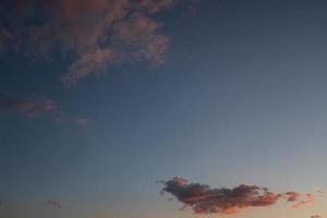 Pink clouds in blue sky photo