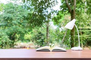 libro y lámpara en el escritorio exterior foto