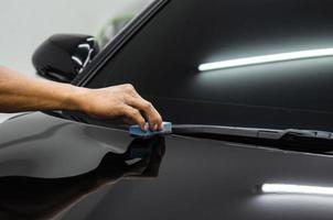 Cleaning the hood of a black car photo