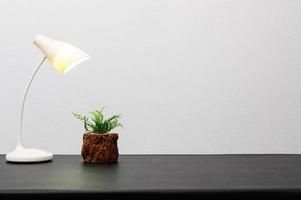 lámpara y planta en el escritorio foto