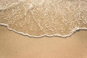 Ocean waves on sandy beach photo