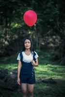 Young girl holding colorful balloons in nature photo