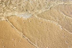 Ocean waves on sandy beach photo