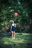 Young girl holding colorful balloons in nature photo