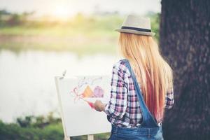 mujer joven hace un dibujo en el parque foto