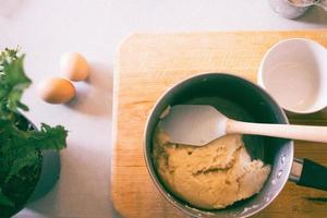 Pot with spatula on chopping board. photo